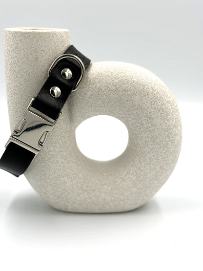 Elegant black leather dog collar with silver hardware, crafted from premium Italian vegetable-tanned leather for refined dogs.