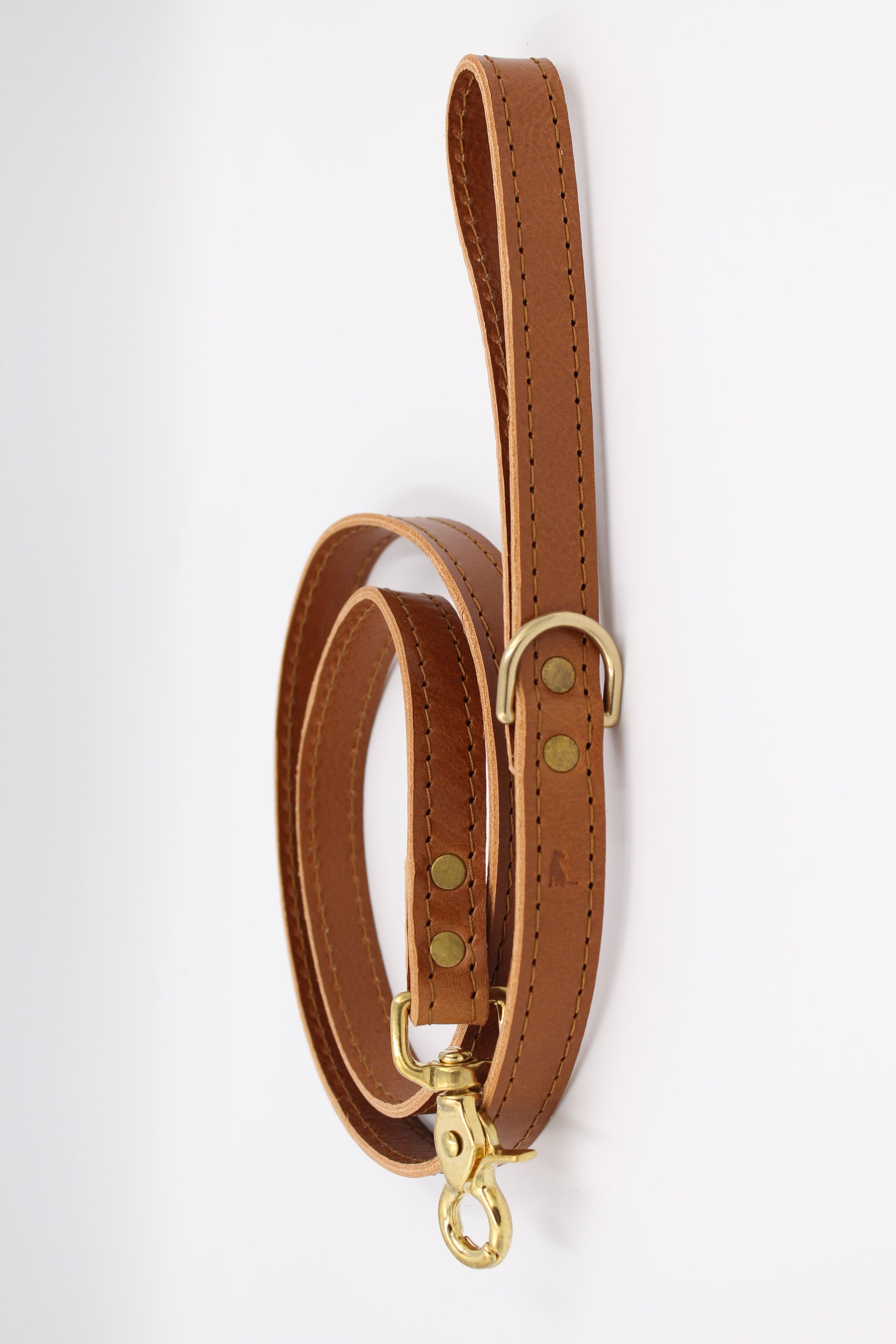 Luxurious caramel leather dog leash with golden brass hardware, designed for superior durability and sophisticated style.